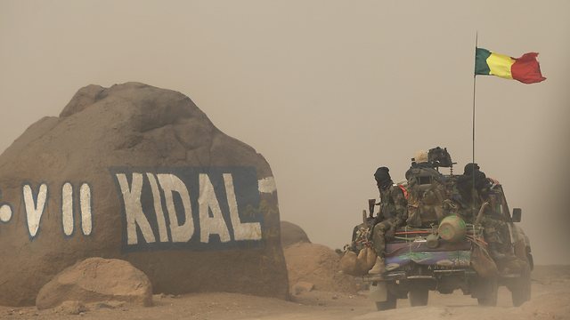חיילים נושאים דגל מאלי בקידאל (צילום: AP) (צילום: AP)