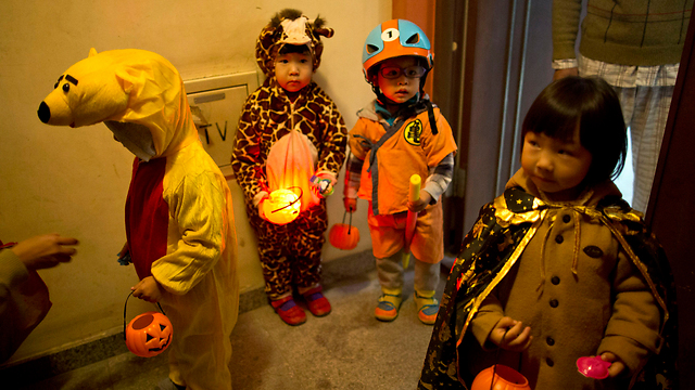 ילדים מחופשים בבייג'ינג עוברים מבית לבית ומבקשים ממתקים לרגל חג ליל כל הקדושים (צילום: AP) (צילום: AP)