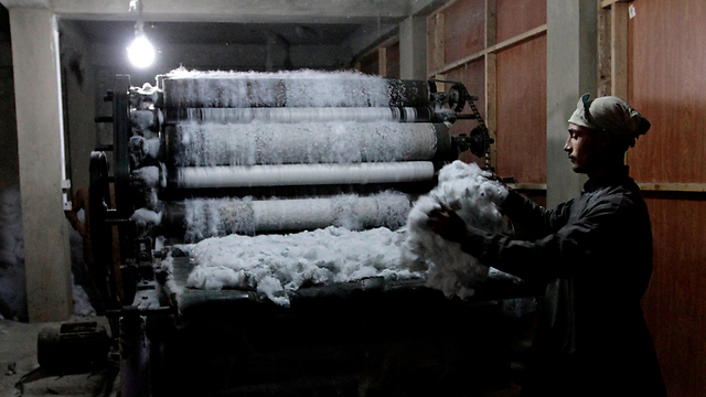 פועל בן 18 עובד במפעל לייצור שמיכות בפאתי קאבול, בירת אפגניסטן (צילום: AP) (צילום: AP)