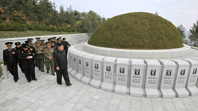 השליט הצפון קוריאני ביקר בבית הקברות בליווי בכירי משטרו (צילום: AFP PHOTO / KCNA VIA KNS) (צילום: AFP PHOTO / KCNA VIA KNS)