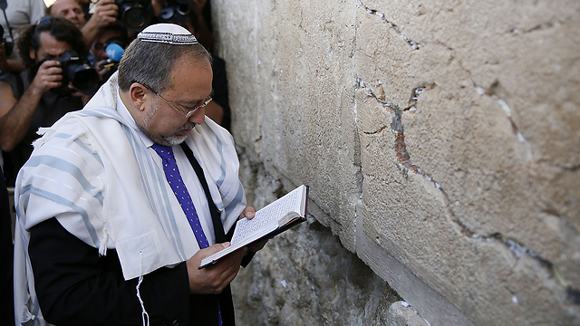 Liberman prays at the Western Wall before hearing the verdict (Photo: AFP)