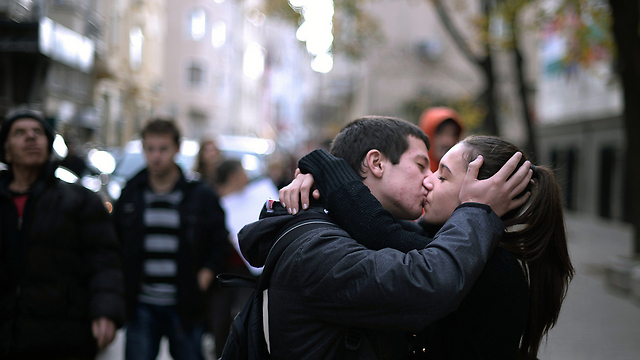 זוג צעיר מתנשק במהלך הפגנת מחאה בסופיה נגד ממשלת בולגריה. במהלך ההפגנה, שבה נעצרו 48 בני אדם ו-4 נפצעו, קראו המפגינים לפיטוריו של ראש הממשלה פלמן אורשרסקי (צילום: AFP) (צילום: AFP)