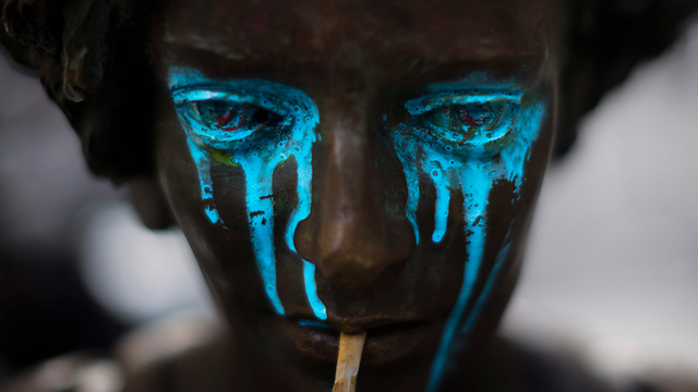 צבע כחול נוזל מן העיניים של פסל שהושחת במדריד (צילום: AP) (צילום: AP)