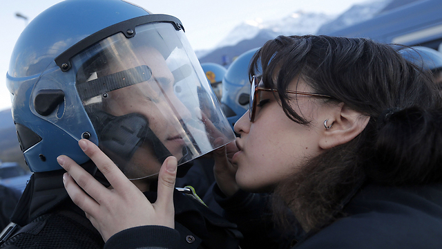 נשיקה צרפתית. מפגינה מביעה חיבה לשוטר  (צילום: AFP) (צילום: AFP)