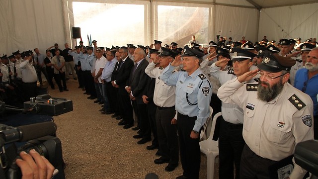 Emergency service and prison security officers salute during the memorial ceremony (Photo: Zohar Shahar)