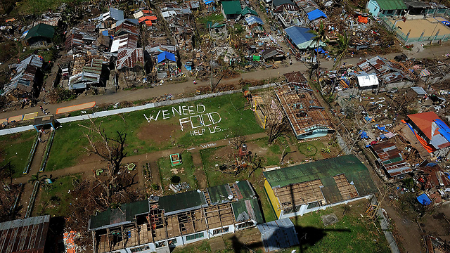 מבט מהאוויר על העיר אורמוק שהוכתה גם היא בטייפון "הייאן" בפיליפינים. תושבי המקום כתבו הודעה שנראית מהשמיים: "אנחנו זקוקים למזון. עזרו לנו" (צילום: AFP) (צילום: AFP)