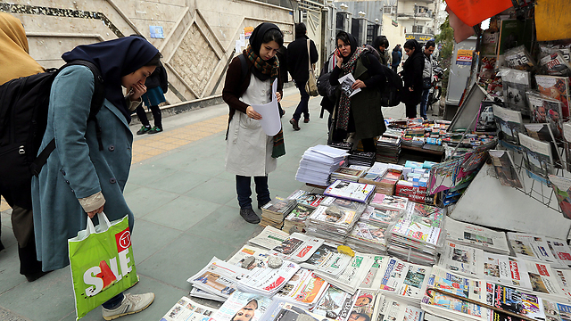 Iranians look at newspapers after signing of nuclear deal (Photo: EPA)