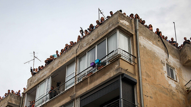 אנשים התקהלו על הגגות מסביב לבית העלמין (צילום: אבישג שאר-ישוב) (צילום: אבישג שאר-ישוב)