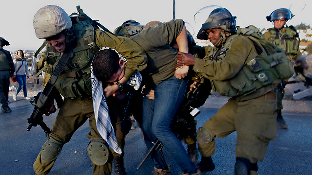 IDF soldiers restraining a man at a protest in West Bank (Photo: AP)