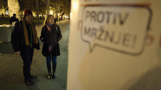 סימיק וסיסק לצד שלט הקורא "נגד שנאה" (צילום: רויטרס) (צילום: רויטרס)
