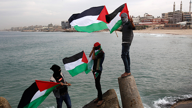 Teens wave Palestinian flags in Gaza (Photo: AP)