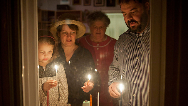Rabbi Zoltan Radnoti lights Hanukkah candles with family (Photo: EPA)