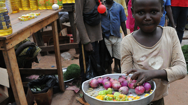 ילדה מוכרת בצלים ופלפלים בשוק בבנגי, בירת הרפובליקה המרכז-אפריקנית (צילום: AFP) (צילום: AFP)