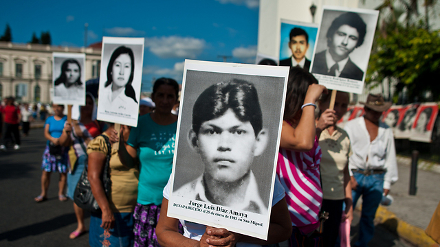 פעילי זכויות אדם באל סלבדור מפגינים בדרישה מהממשלה לשפוט חיילים שהיו מעורבים לכאורה במקרי טבח במלחמת האזרחים במדינה בשנים 1992-1980 (צילום: AFP) (צילום: AFP)