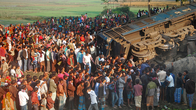 תושבים מתאספים סביב שברי רכבת נוסעים שירדה מהפסים בעיר גייבנדה בצפון בנגלדש (צילום: AFP) (צילום: AFP)