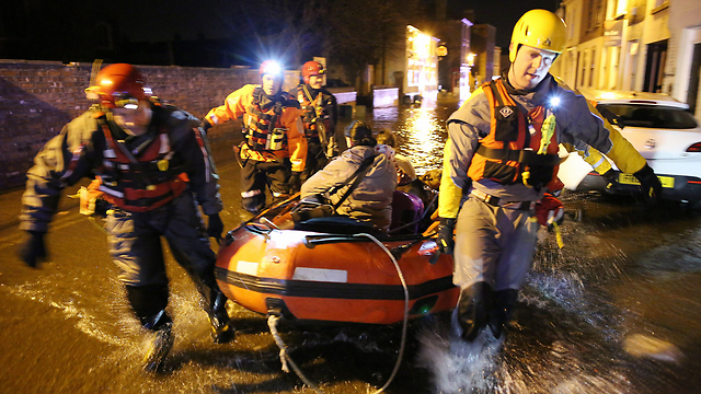 צוות חילוץ נושא פצוע בסירת גומי ליד העיר בוסטון באנגליה שהוכתה בשיטפונות גדולים (צילום: גטי אימג'בנק) (צילום: גטי אימג'בנק)