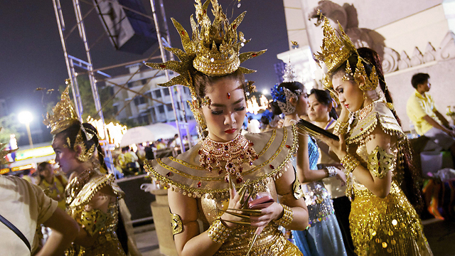 רקדניות בבנגקוק בהפוגה קצרה מהחגיגות לציון יום הולדת 86 למלך תאילנד בהומיבול אדולידג' (פומיפון אדוניאדט) (צילום: גטי אימג'בנק) (צילום: גטי אימג'בנק)