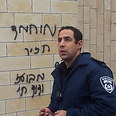 Police officer walks by 'Mohammed is a pig' graffiti  (Photo: Hassan Shaalan)