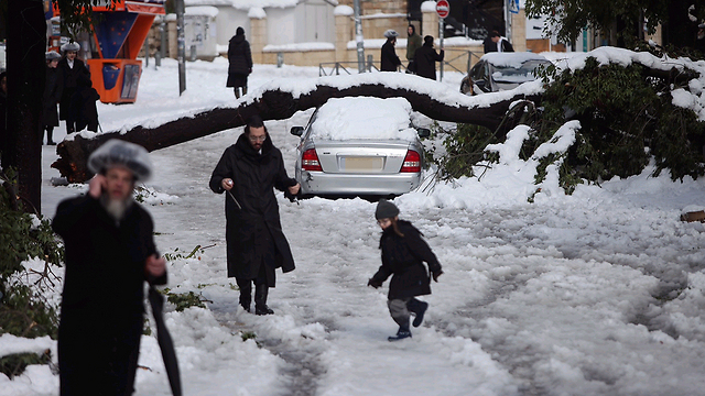 DECEMBER 13: Members of Jerusalem's Haredi community struggle through the snow after winter storms blanketed the capital in white (Photo: Ohad Zweigenberg) (Photo: Ohad Zweigenberg)