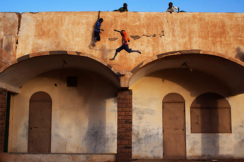 ילדים משחקים על גג כניסה לאצטדיון כדורגל בעיר גאו במאלי (צילום: רויטרס) (צילום: רויטרס)