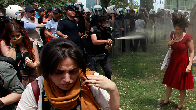 שוטר טורקי מרסס בגז מדמיע מפגינה במרכז איסטנבול (צילום: רויטרס) (צילום: רויטרס)