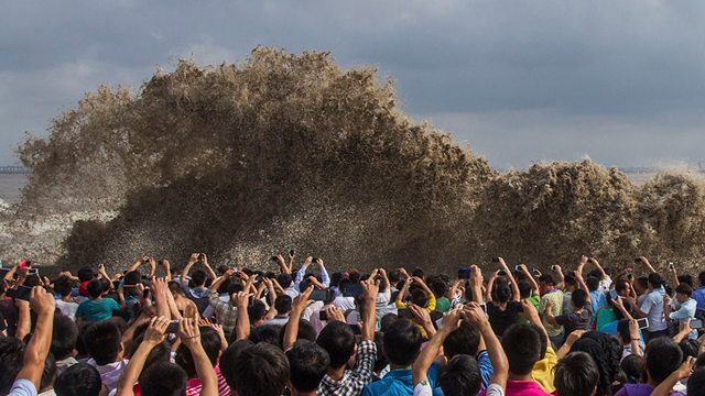 תיירים מצלמים גלים שנוצרו מטייפון "אוסאגי" בעיר האנגג'וֹאוּ בסין (צילום: רויטרס) (צילום: רויטרס)