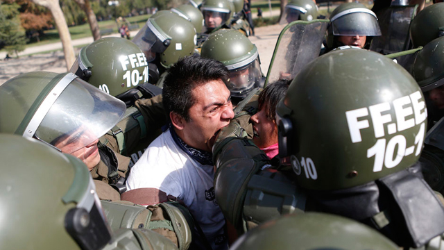 סטודנט נושך שוטר בעת מעצרו במהלך הפגנה בעיר סנטיאגו שבה דרשו המפגינים מממשלת צ'ילה לבצע רפורמות במערכת החינוך (צילום: רויטרס) (צילום: רויטרס)