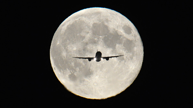 מטוס נוסעים על רקע ירח מלא בשיא אורו (צילום: רויטרס) (צילום: רויטרס)