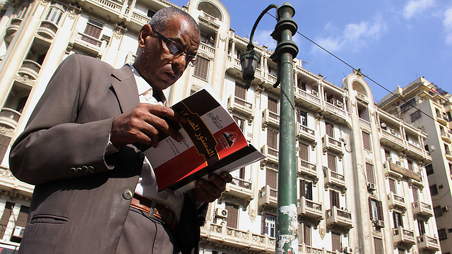 אזרח מצרי קורא את טיוטת החוקה החדשה (צילום: AP) (צילום: AP)