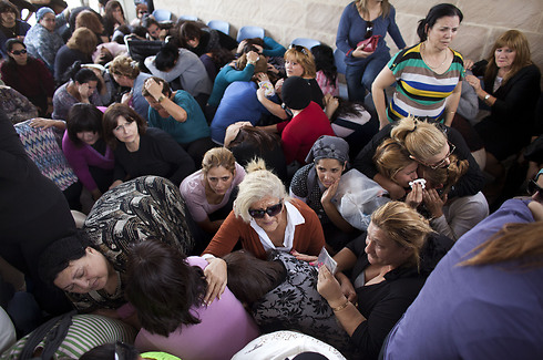 נשים תופסות מחסה בזמן אזעקה במהלך טקס ההלוויה של יצחק אמסלם, שנהרג יום קודם לכן בקריית מלאכי (צילום: אוריאל סיני / גטי אימג'ס) (צילום: אוריאל סיני / גטי אימג'ס)