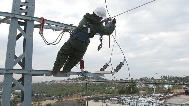 A worker fixes an electric cable after the storm (Photo: Yossi Weis)
