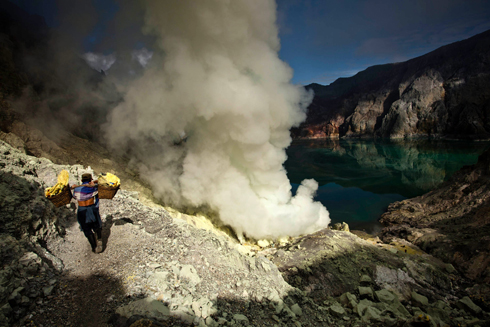 כורה פחם נושא סלים עם גופרית על הר הגעש לג'ן באי ג'אווה שבאינדונזיה במהלך טקס מסורתי של הקרבת עז וקבירתה ליד לוע ההר. הטקס מתבצע כדי להרחיק אסונות פוטנציאליים בשנה הבאה (צילום: גטי אימג'בנק) (צילום: גטי אימג'בנק)