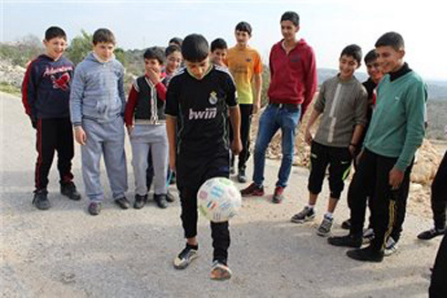 The children playing with a replacement ball (Photo: Ma'an)