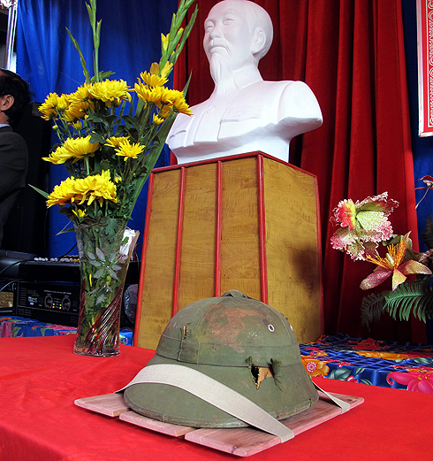 הקסדה על רקע פסלו של מייסד ומנהיג צפון וייטנאם הו צ'י מין (צילום: AP) (צילום: AP)