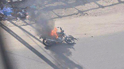 A burning motorcycle lies on the ground following the IAF strike