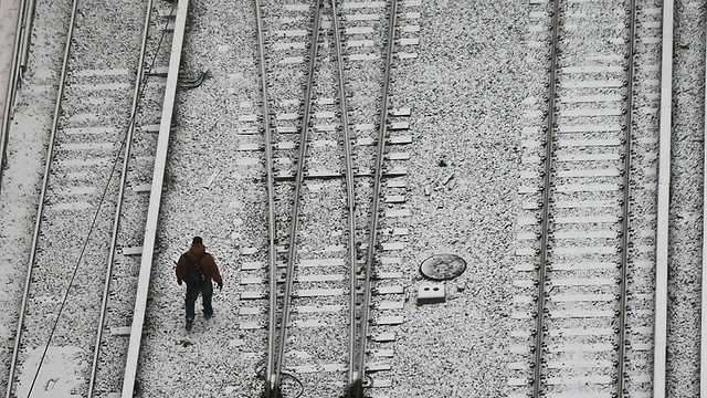 אדם צועד בין מסילות רכבת בניו יורק (צילום: AP) (צילום: AP)