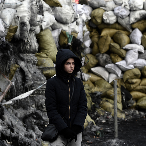 מפגינה צעירה עומדת ליד עמדה מבוצרת בקייב. המדינה הסובייטית לשעבר עומדת על סף מלחמת אזרחים על רקע מחאות האופוזיציה על ההתרחקות מהאיחוד האירופי וההתקרבות לרוסיה (צילום: AFP) (צילום: AFP)