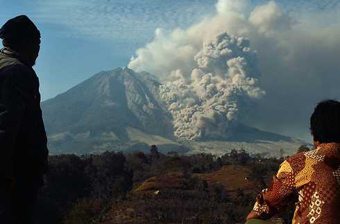 תושבי האי סומטרה שבאינדונזיה צופים מרחוק בהר הגעש סינאבונג שבתחילת החודש התפרץ וגרם למותם של 16בני אדם. יותר מ-30 אלף איש אולצו לפנות את בתיהם בשל התפרצות הר הגעש (צילום: AFP) (צילום: AFP)