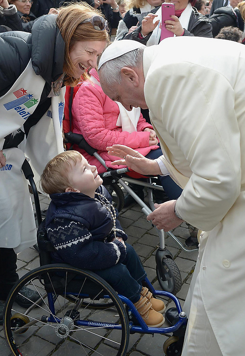 ראש הכנסייה הקתולית מברך ילדה על כיסא גלגלים (צילום: EPA) (צילום: EPA)