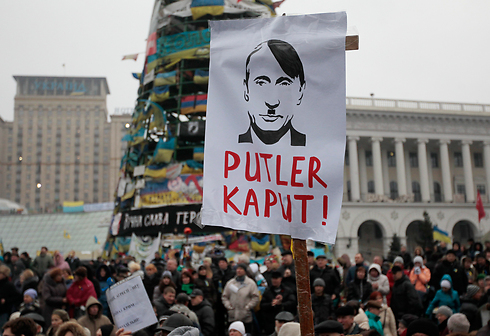 קריקטורה של פוטין בדמות היטלר בהפגנה בקייב (צילום: AP) (צילום: AP)