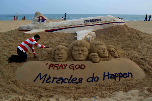 "התפללו לאלוהים - נסים אכן קורים". אמן חול הודי בתחינה למרומים (צילום: AFP) (צילום: AFP)