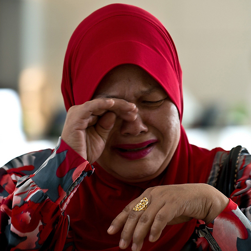 רוצים תשובות. קרובת משפחה של אחד הנוסעים הנעדרים (צילום: AFP) (צילום: AFP)