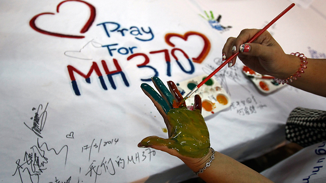 אחת הטרגדיות הגדולות של השנה. מתפללים לשלום טיסה MH370 של "מלזיה איירליינס" (צילום: AP) (צילום: AP)