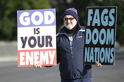 "אלוהים הוא האויב שלכם", "הומואים מובילים אומות לאבדון". חבר הכנסייה מפגין (צילום: AFP) (צילום: AFP)