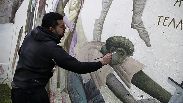 האומן היווני פיקוס מצייר על קיר באתונה                (צילום: AP) (צילום: AP)