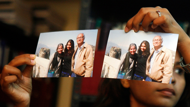 משפחתה של צ'נדריקה שרמה מציגה את תמונותיה (מצולמת משמאל) (צילום: AP) (צילום: AP)
