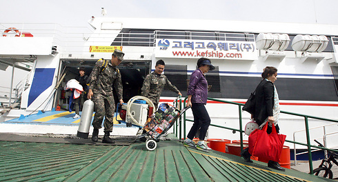 נחתים ואזרחים יורדים ממעבורת שתוכננה להפליג לאי יואנפיונג (צילום: AP) (צילום: AP)