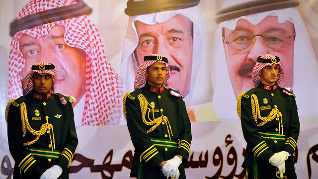 חיילי משמר סעודי על רקע תמונות המלך עבדאללה, יורש העצר סלמאן בן עבד אל-עזיז ויורש העצר השני הנסיך מוקרין בן עבד אל-עזיז (צילום: רויטרס) (צילום: רויטרס)