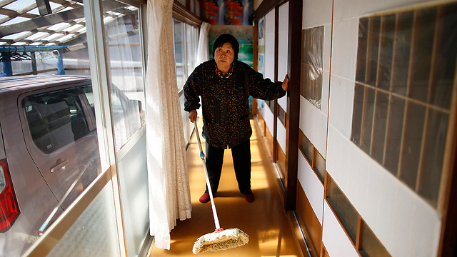 מנקה את הבית אחרי שנעדרה ממנו 3 שנים. קימיקו קויאמה בעיר טאמורה (צילום: רויטרס) (צילום: רויטרס)