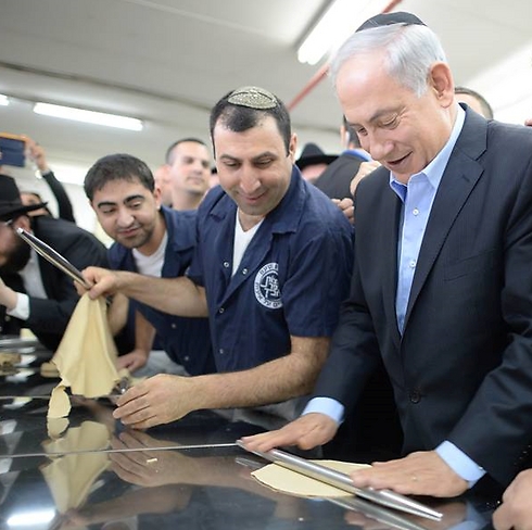 Netanyahu flattening a matzah (Photo: Kobi Gideon, GPO)